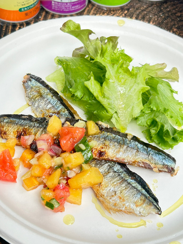 岡山県で活動する料理サークル『ちゃお～！』のアウトドア活動にて、炭火で香ばしく焼いたサンマに彩り豊かな柿のラビゴットソースを添えた料理写真