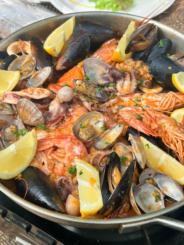 岡山県料理サークルちゃおでメンバーがアウトドアで調理した、エビやムール貝がたっぷり入った本格シーフードパエリア。