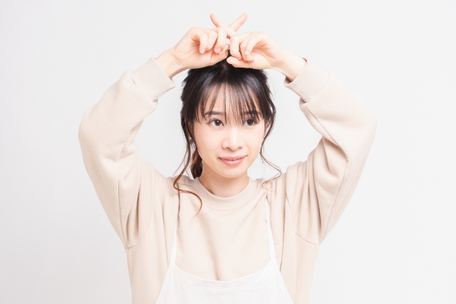 「料理サークル『ちゃお～！』 のルールや禁止事項を説明する、頭の上で指を交差させてバツ印を作るエプロン姿の女性の画像」